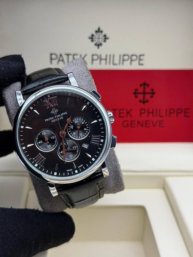 Patek Philippie chronograph watch with leather strap, sleek silver case, and black dial featuring chronograph subdials